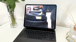 Apple iPad Pro 13-inch M4 tablet on white wooden surface with tyres on screen
