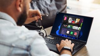 Rückansicht eines Mannes, der auf einem Windows-11-Laptop den Microsoft Store geöffnet hat