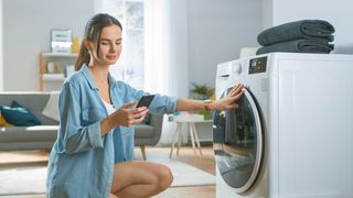 Woman connecting app to smart washing machine