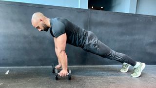 a photo of Ali Malik performing a dumbbell renegade row