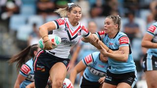  Rooster Jocelyn Kelleher (L), in white, hands off a Sharks player in the NRLW.