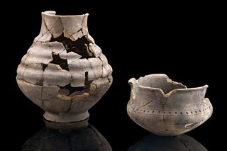 Two cracked ceramic pots with some pieces missing