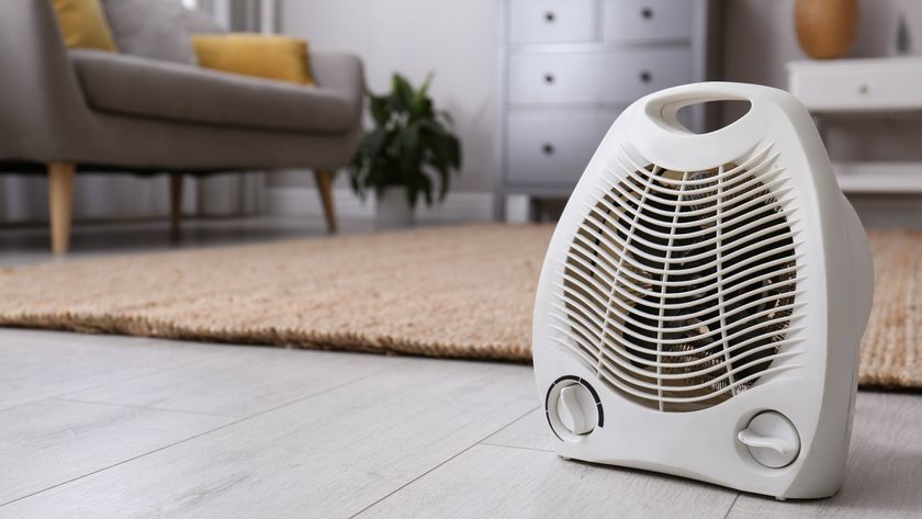 A space heater in a living room next to a rug and sofa