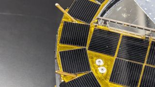 A close look at a metallic yellow instrument with solar panels.