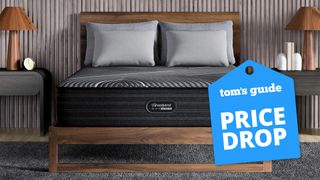 The Beautyrest Black Hybrid mattress on a wooden bed frame in a bedroom, a Tom's Guide price drop deals graphic to the right