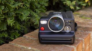 The Polaroid I-2 instant camera on a brick wall in the sunshine