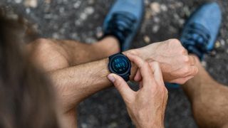 A runner looking at their running watch 