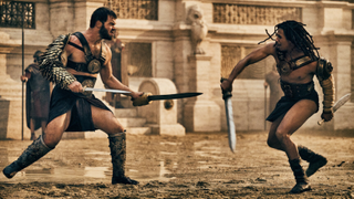 Gladiators Viggo (Johannes Haukur Johannesson) and Kwame (Moe Hashim) fighting with swords in the Colosseum in Those About to Die