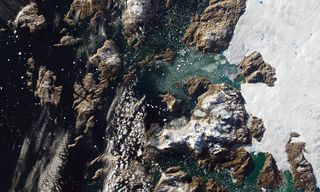 satellite view of ice, land and water showing an area of greenland