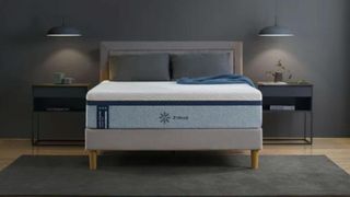 The Zinus Ultra Cooling Green Tea mattress against a dark gray wall and placed on a wooden bed frame