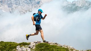 a photo of a man running with a hydration backpack