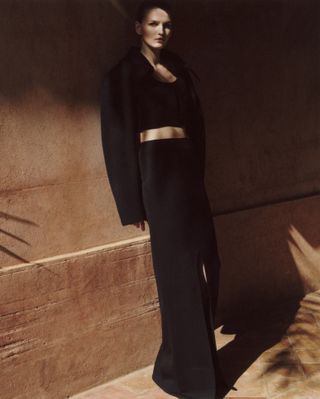 Model wears black against backdrop of Moroccan hotel