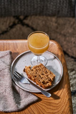 Banana Bread Daiquiri cocktail next to slice of banana bread on plate