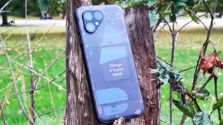 The Fairphone 5 leaning on a tree stump.