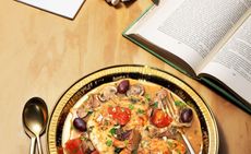 A plate of food on a table with an open book