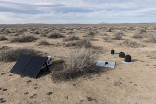 microphones and wind gauges connected to solar panels in the desert