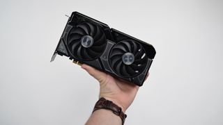 A man&#039;s hand holding up the Nvidia RTX 4060