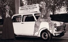 Man and woman with old styled white vehicle