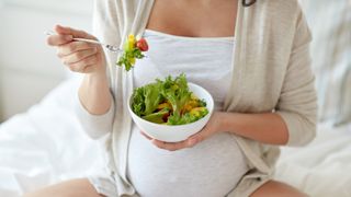 Pregnant woman eating salad