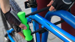 Best bike locks: Pictured here, a man securing bike to rack using U-lock