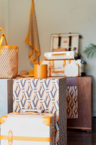 Close-up of a candle and suitcase offerings in the shop