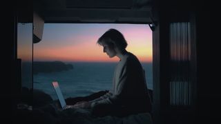 Asus promotional video for its new laptop showing a woman working on a computer overlooking the sea