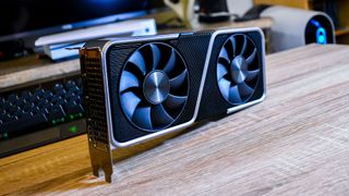 Nvidia GeForce RTX 3070 står på et bord foran et tastatur og pc i baggrunden.