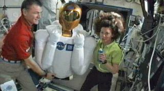 NASA astronaut Cady Coleman (right) and Italian astronaut Paolo Nespoli proudly display the newest resident of the International Space Station, the humanoid Robonaut 2 robot, to cameras on March 15, 2011.