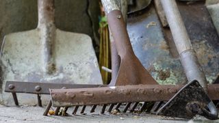 A rusty rake lying on the floor