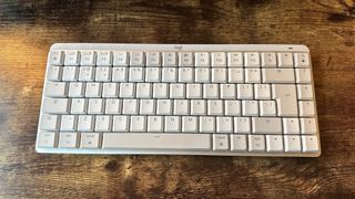 The Logitech MX Mechanical Mini for Mac on a wooden desk