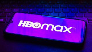 The HBO Max logo on a phone on top of a keyboard