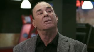 Jon Taffer looks down with an expression of question in a bar on Bar Rescue.
