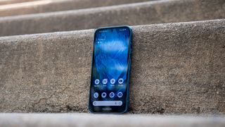 The colorful home screen of the Google Pixel 8a on the stairs