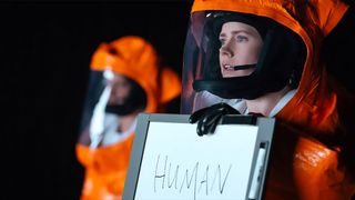 Amy Adams holds up a sign reading HUMAN in Arrival