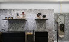 Shop interior of Greek Jewellery designer Ileana Makri with wooden floors, black cabinets, glass display cabinets and gold mirrors