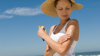 Woman applying sunscreen at the beach