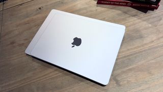 The 2024 MacBook Air M3 on a wooden table in front of a bookshelf.