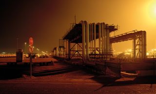 An industrial structure with pipes running over the top of it.