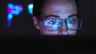 Engineer designing AI technology with reflection on eyeglasses