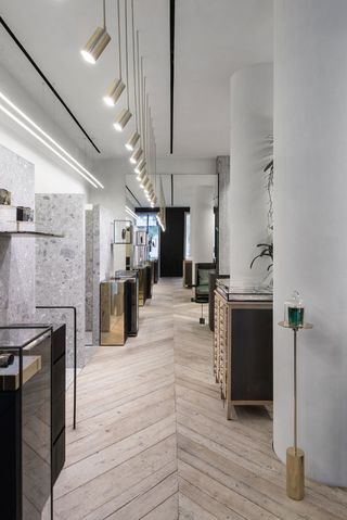 Shop interior of Greek Jewellery designer Ileana Makri with wooden floors, black cabinets, glass display cabinets and gold mirrors