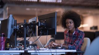 A person looks inquisitively at one screen of a dual monitor configuration, representing an article about how to fix a second monitor not detected