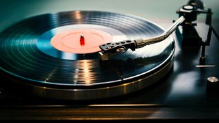 Turntable with tonearm playing a black vinyl record