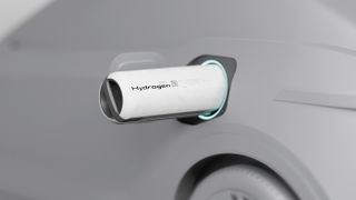 A hydrogen battery sticking out the side of a grey car