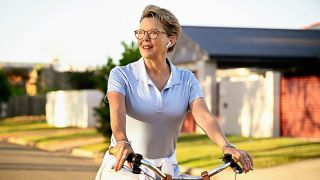 Annette Bening as Joy Delaney riding a bicycle through suburbia in "Apples Never Fall"