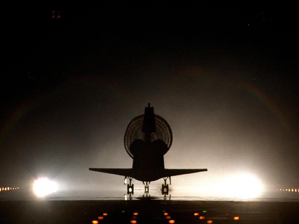 With its drag chute fully deployed, space shuttle Discovery lands on Kennedy&#039;s brightly lighted Shuttle Landing Facility runway 15, completing the 9-day, 19-hour, 13-minute and 1-second STS-96 mission. Main gear touchdown was at 2:02:43 a.m. EDT June 6, l