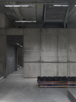 Inside empty Balenciaga store with concrete walls and fixtures