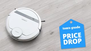 Image of Ecovacs Deebot robot vacuum on grey wood flooring and Toms Guide price drop logo on right