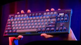 A pair of hands holding up the Cherry XTRFY MX 8.3 TKL wireless gaming keyboard