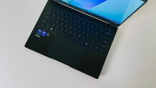 The keyboard deck of the Asus Vivobook S14 seen from above on a white table