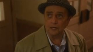 Bob Newhart wearing a hat and a tan raincoat in NCIS